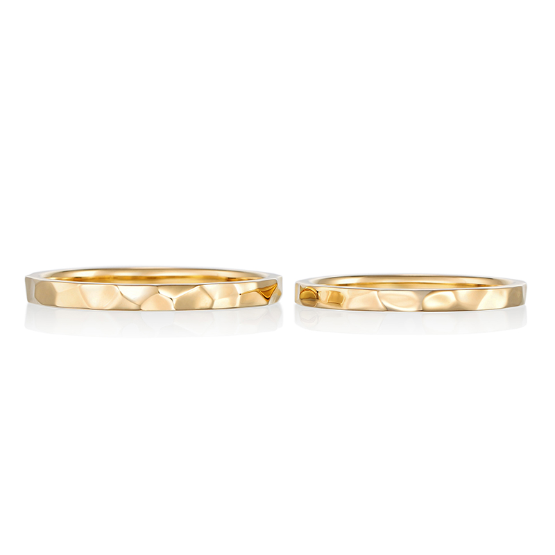 
ゴールドに槌目デザインを彫り込んだ結婚指輪。肌なじみの良いイエローゴールドが手元で上品に光ります。