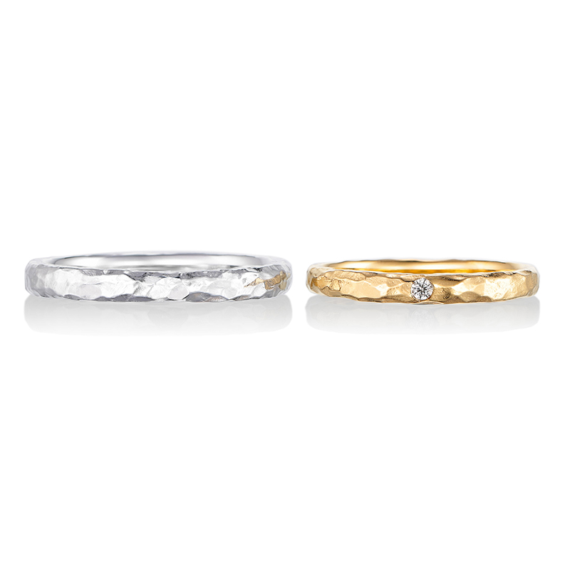 
細かく入れられた槌目デザインが大人っぽい印象を与える結婚指輪。センターに留められた一粒のダイヤモンドが上品な印象を与えます。